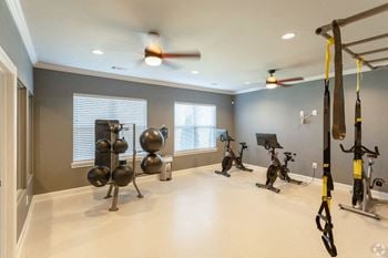 A group exercise room with yoga and cardio equipment